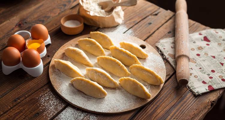Raw pastries on a wooden board with baking ingredients.