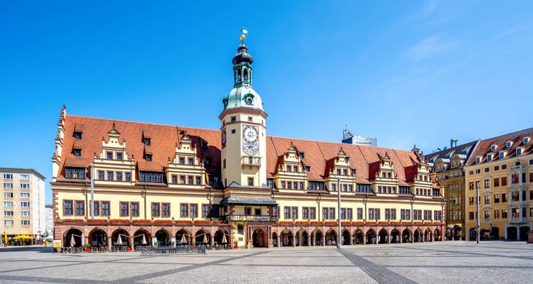 Place de la ville avec un bâtiment historique et une tour d'horloge.