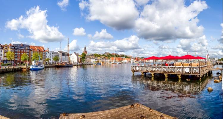 Panoramic view of a vibrant harbor town with colorful buildings and boats.
