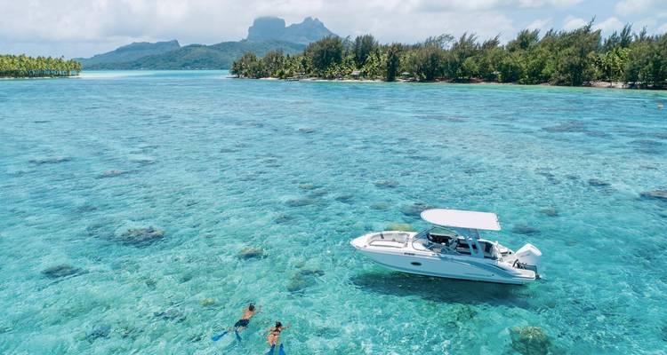 Boot in kristallklarem Wasser mit Schwimmern