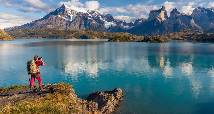 Persoon die een foto maakt van schilderachtige bergen en een meer.