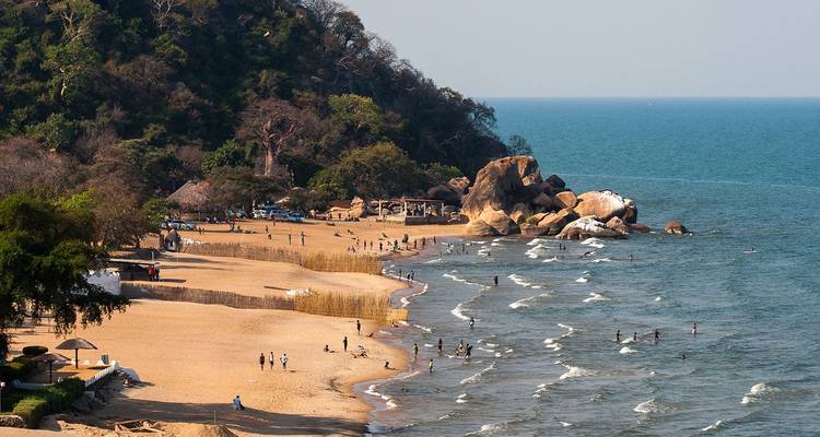 Locals and visitors enjoying the sandy shoreline and gentle waves of Lake Malawi.