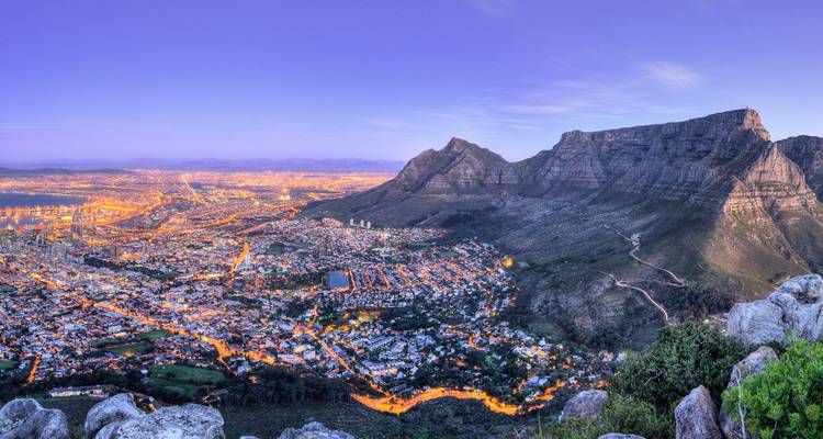 Dramatisch schemeringpanorama van de stadslichten van Kaapstad onder de massieve Tafelberg