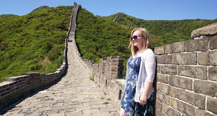 Eine Frau, die auf der Chinesischen Mauer steht, mit Grünzeug.