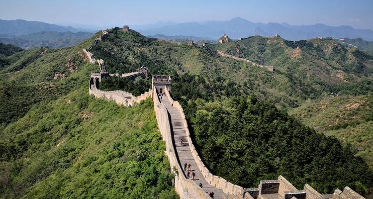 Die Chinesische Mauer schlängelt sich über Hügel unter klarem Himmel.