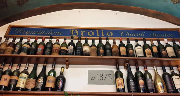 Surtido de botellas de vino en estantes de madera etiquetadas con 'Broglio'.