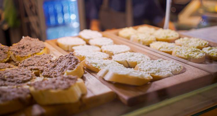 Surtido de rebanadas de pan con diferentes untables en exhibición.