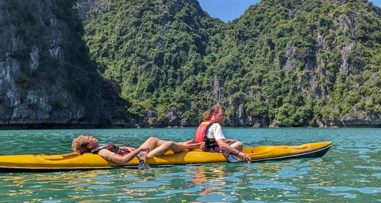 Deux personnes faisant du kayak dans des eaux turquoise entourées de falaises calcaires.