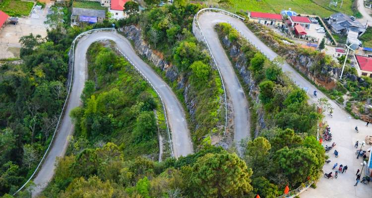 Vista aérea de carreteras serpenteantes de montaña rodeadas de vegetación verde.
