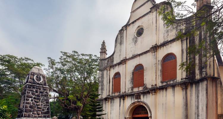 Église historique avec une façade en pierre et des arbres à proximité.