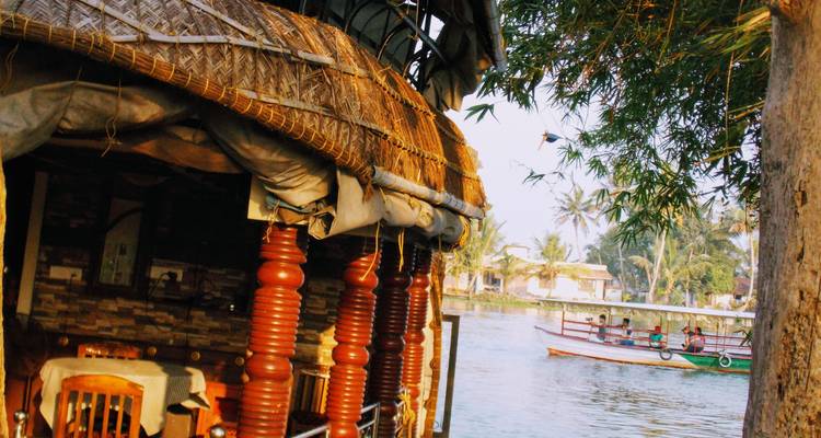 Péniche amarrée sur une rivière avec des personnes sur un bateau à proximité.