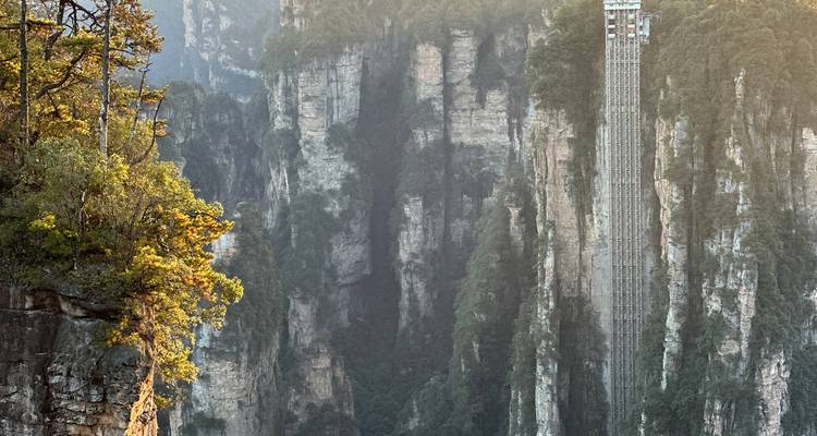 Elevator built into the side of a karst cliff with lush surroundings.