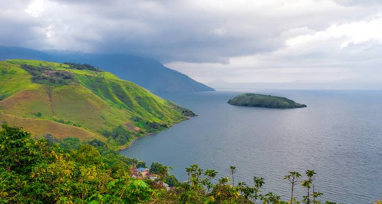 Isolated island observed at Lake Toba with lush vegetation.