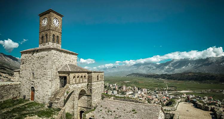 Ein historischer Uhrenturm mit Blick über ein Tal und eine Stadt.