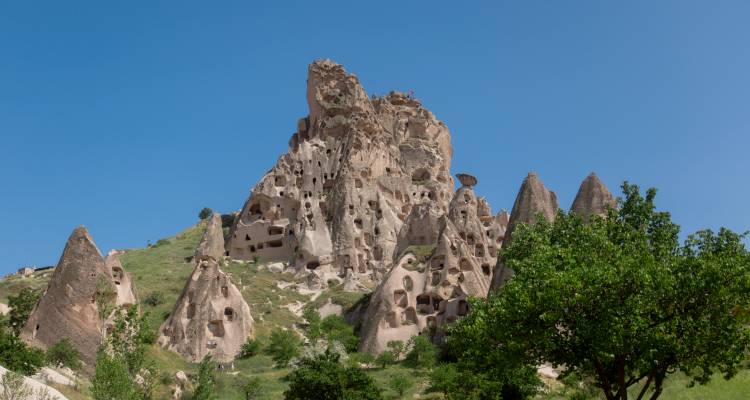 Rocky landscape with ancient cave dwellings carved into the hills.