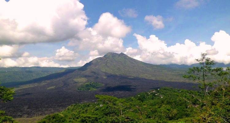 Montagne volcanique avec une végétation luxuriante et un ciel dégagé.