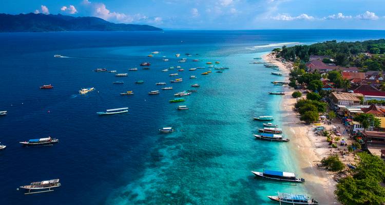 Coastal town with boats on clear blue water.