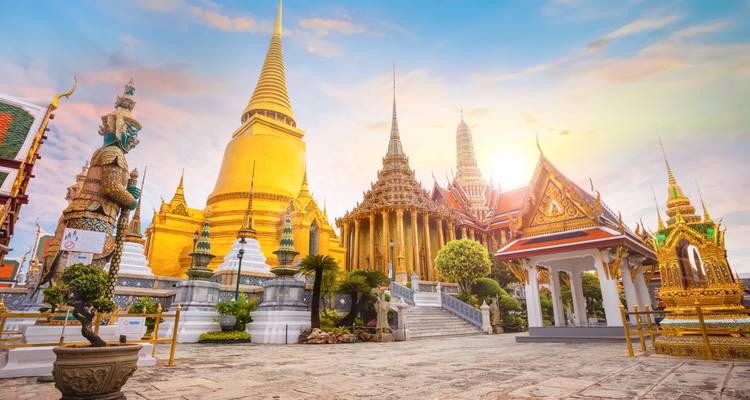 Pagode dorée et temples ornés dans une cour.