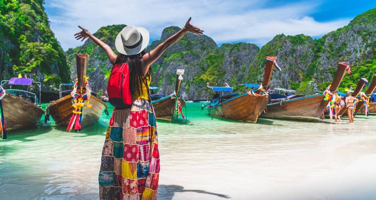 Personne profitant d'un cadre de plage vibrant avec plusieurs bateaux et une eau claire.