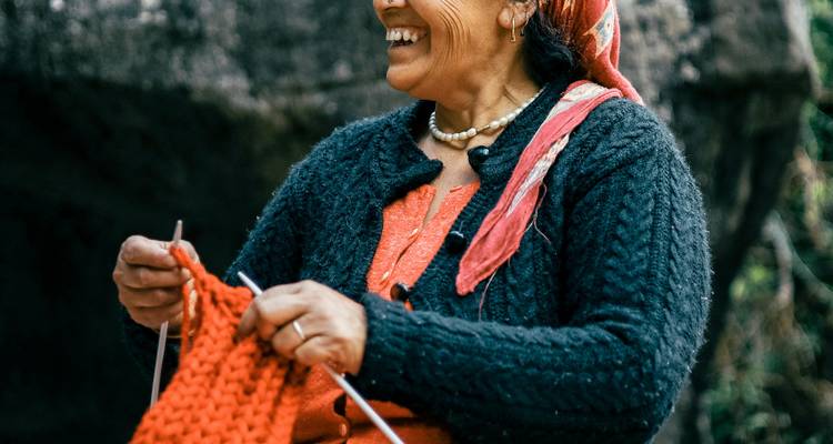 Vrouw breiend met levendig rood garen.
