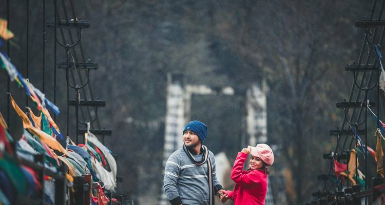 Stel dat staat op een brug met gebedsvlaggen.