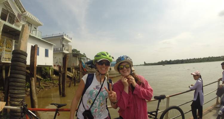 Deux cyclistes posant sur une berge avec un vélo.