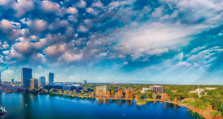 Aerial view of a park with high-rise buildings and a lake.