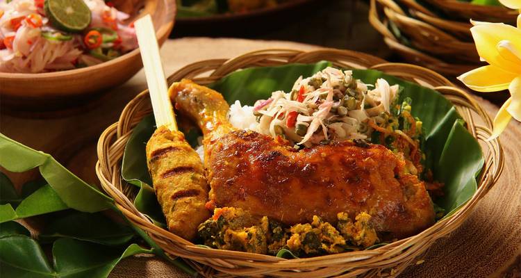 Una apetitosa comida de Sri Lanka que presenta pollo a la parrilla, arroz y acompañamientos de verduras coloridas servidos en una canasta tejida.