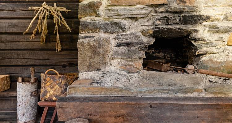 Steinkamin mit einem geflochtenen Korb und Holz.