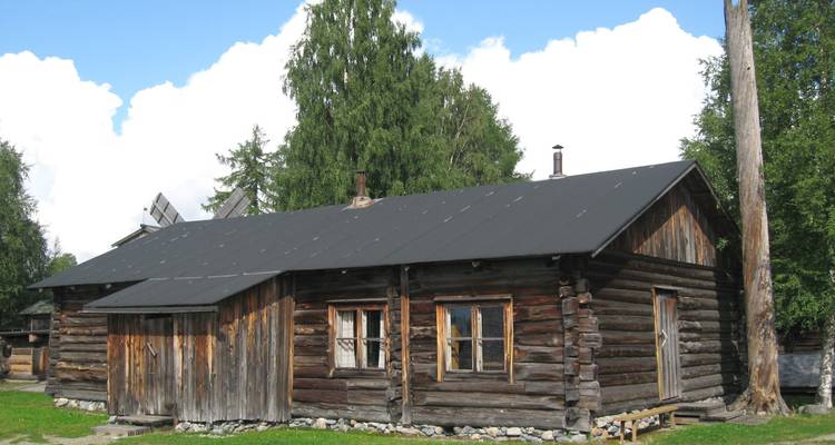 Holzhütte mit grünem Rasen.