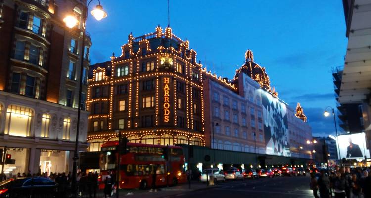 Harrods-Gebäude in London, abends mit Lichtern geschmückt.