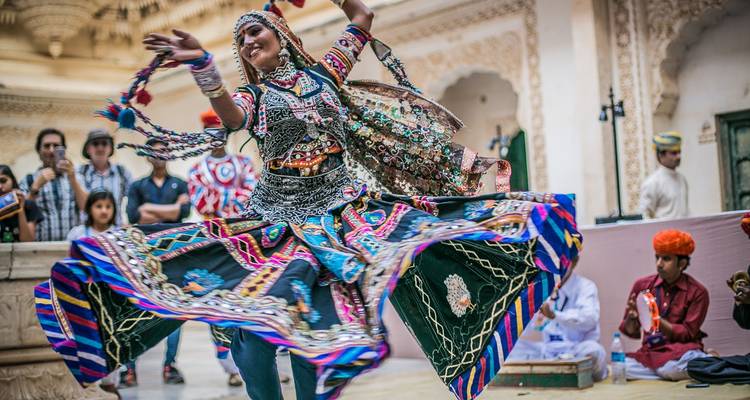 A woman performing a traditional dance in vibrant attire.