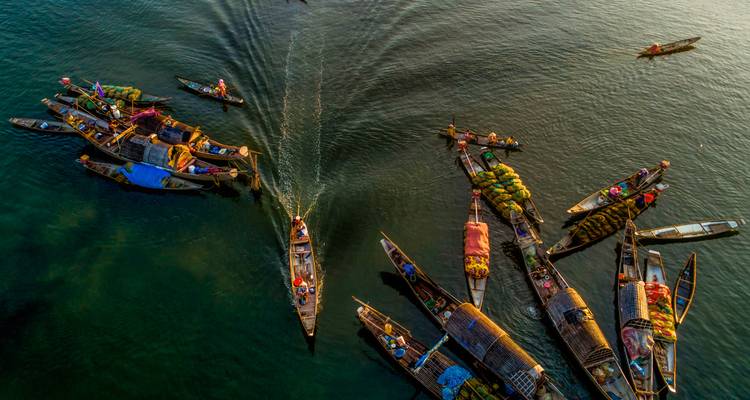 Aerial view of boats and people in a calm river.