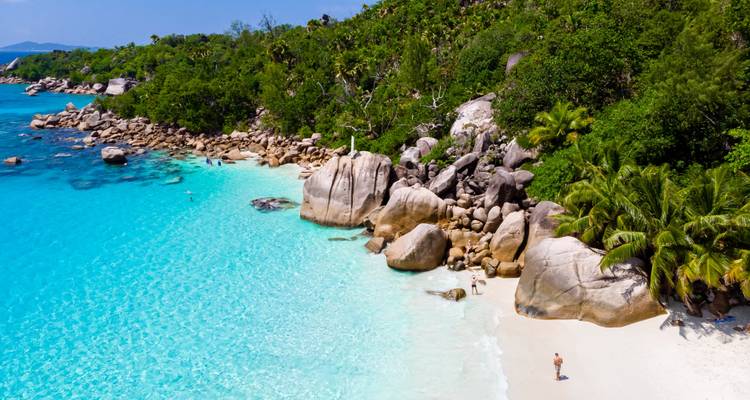 Pristine beach with clear water and rocky formations.