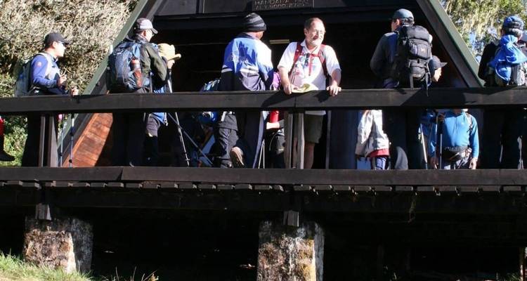 Gruppe von Wanderern, die sich nach einer Wanderung auf einer Holzkonstruktion ausruht.