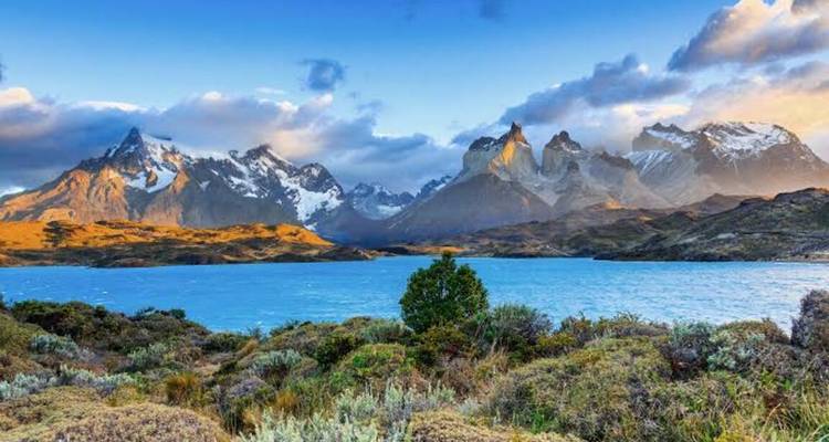 Les pics dentelés emblématiques de Torres del Paine se dressent au-dessus d'un lac bleu sous un ciel dramatique.