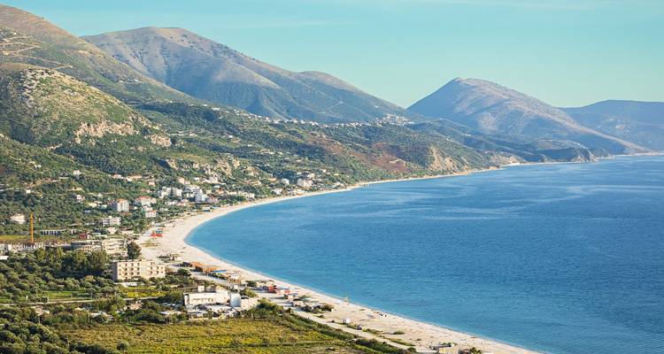 Charmante ville côtière adossée à des montagnes verdoyantes et dotée d'une longue plage de sable blanc.