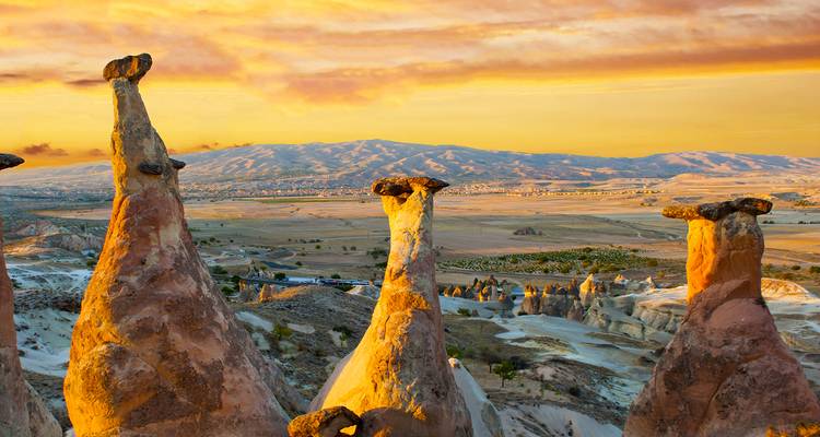 Rock formations at sunset in Cappadocia, Turkey with a colorful sky.