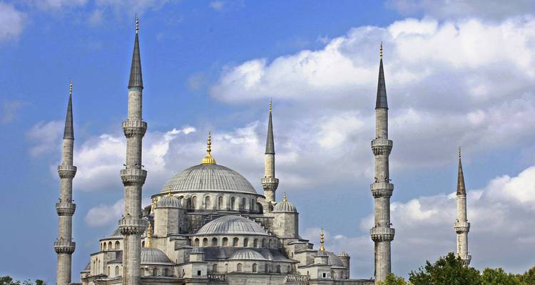 Dagtijdse uitzicht op de zes slanke minaretten van de Blauwe Moskee die tegen een gedeeltelijk bewolkte hemel omhoog rijzen.