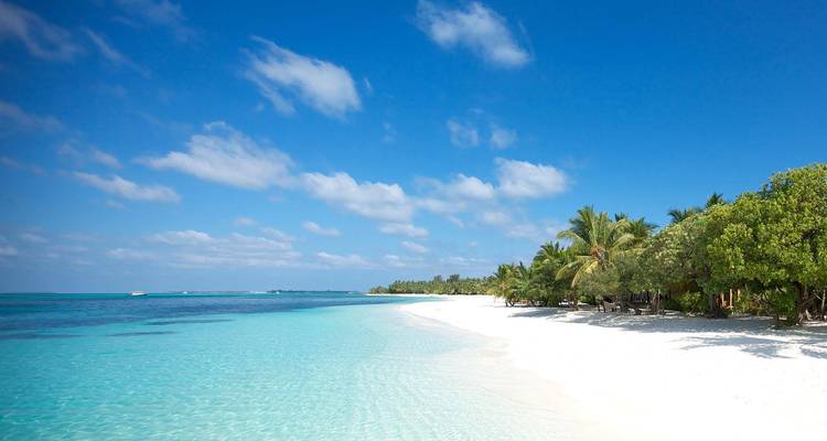 Een ongerept, verlaten strand met turquoise water.