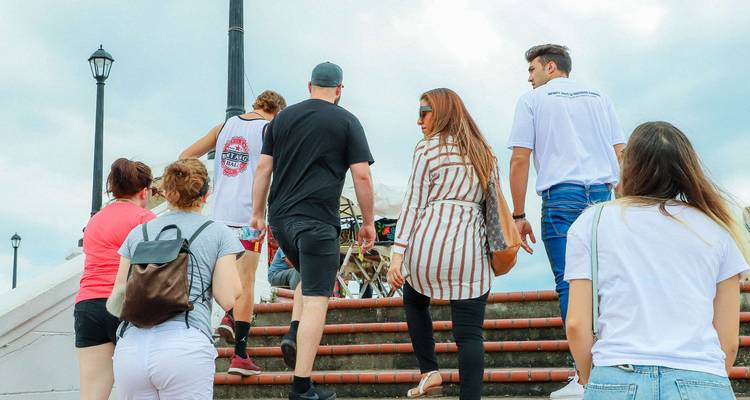 Un grupo de turismo sube las escaleras al aire libre juntos durante un tour a pie.