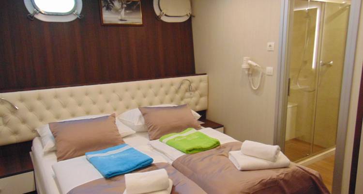 Gemütliche Kreuzfahrtschiff-Kabine mit Doppelbett and modernem Badezimmer.
