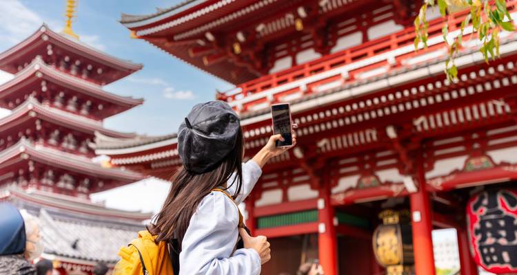 Ein Tourist, der ein Selfie vor einer historischen Pagode macht.