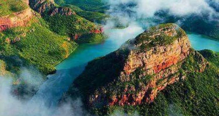 Luchtfoto van een kronkelende rivier omringd door weelderig bergachtig landschap.