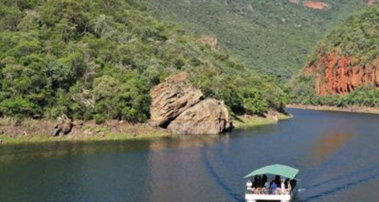 Boot met passagiers die door een rivier reist door een canyon.