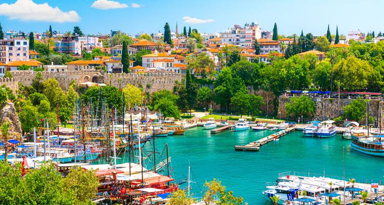 Lebendiges Hafenviertel mit Booten und bunten Gebäuden.