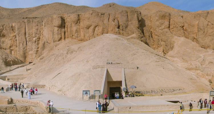 Des touristes visitant la Vallée des Rois avec des falaises en arrière-plan.