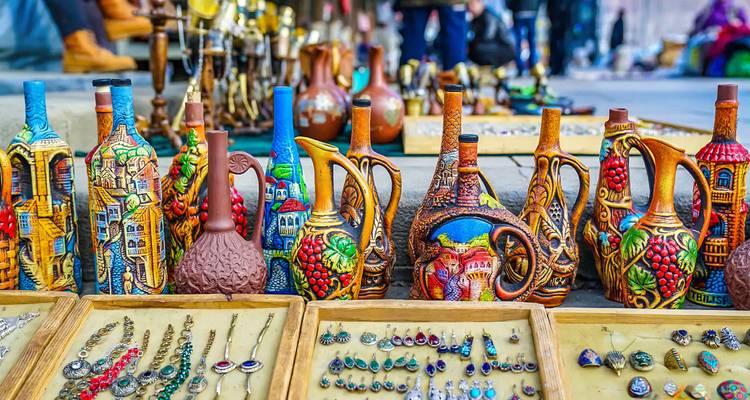 Jarras de cerámica artesanal coloridas y joyería exhibidas en puestos de mercado en un bazar al aire libre