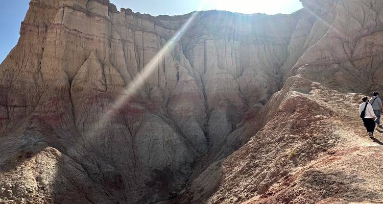 Véhicule tout-terrain sur une route boueuse sous un ciel nuageux.