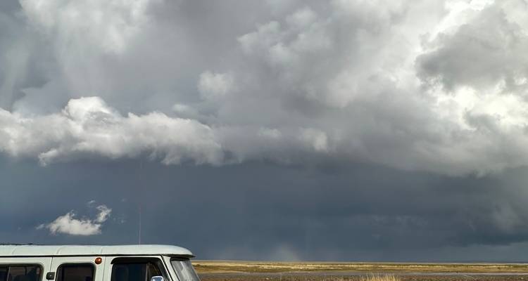 Vue paysage avec nuages et un véhicule, apparaissant incorrectement pivotée.